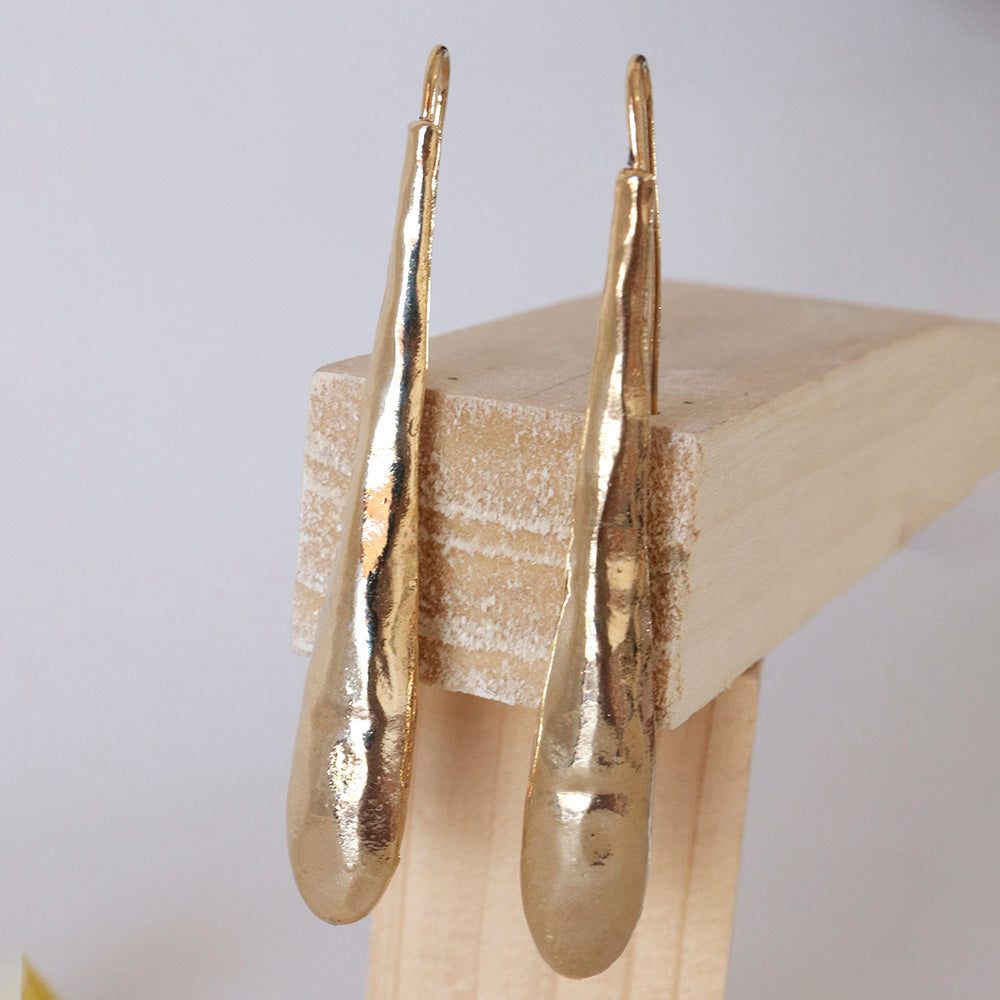 Pendientes largos de metal dorado con acabado texturizado, estilo moderno y elegante. Perfectos para cualquier ocasión.