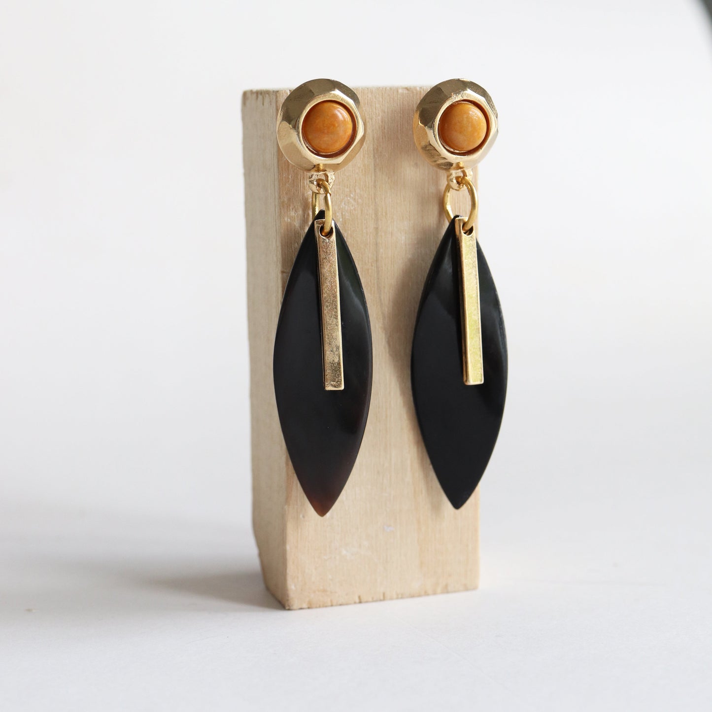Pendientes elegantes de acero dorado con detalle en ámbar y charm negro en forma de hoja. Ideal para ocasiones especiales.