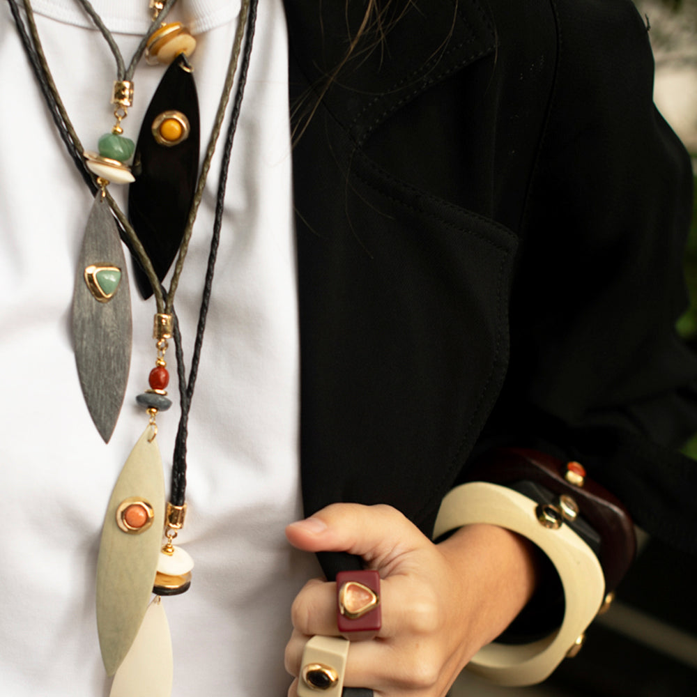 Collar elegante de piedras naturales y metales dorados, con tonos grises y anillos a juego, estilo moderno y sofisticado.