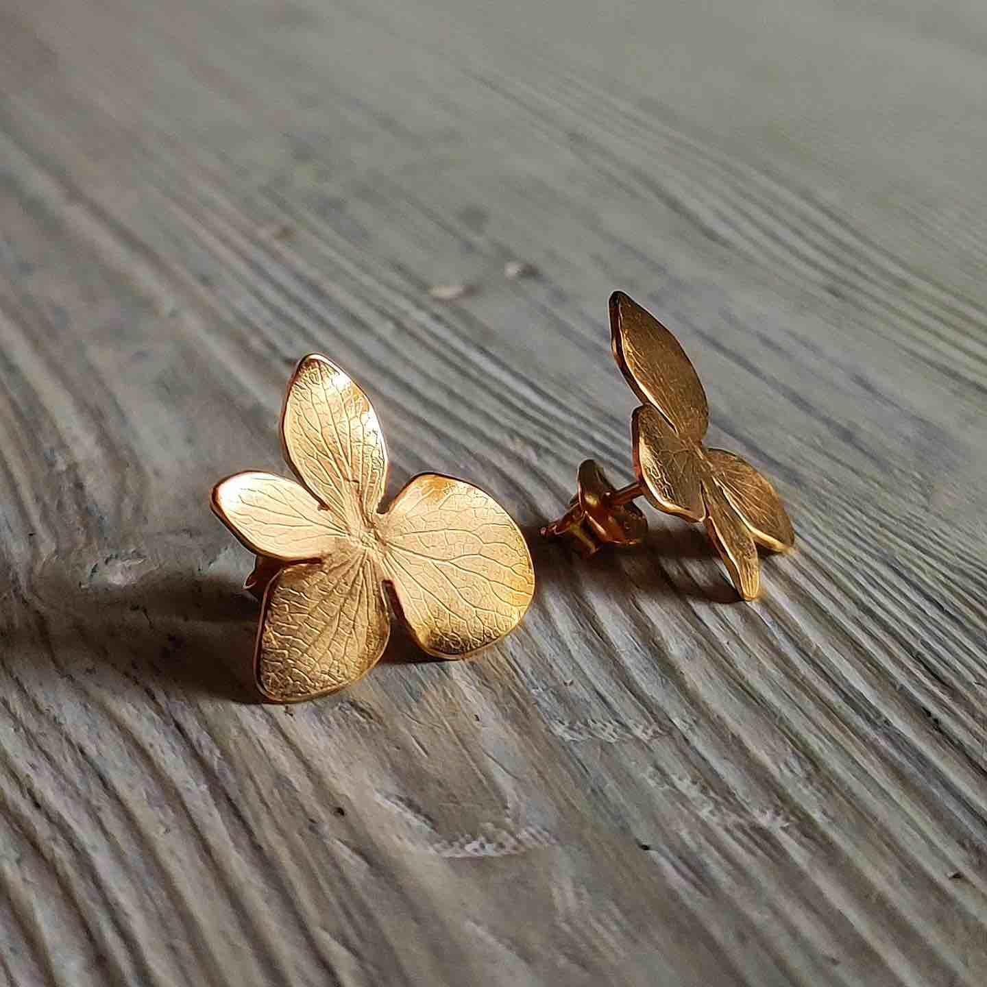 Pendientes de mariposa dorados de metal, con acabado texturizado, elegantes y modernos para cualquier ocasión.