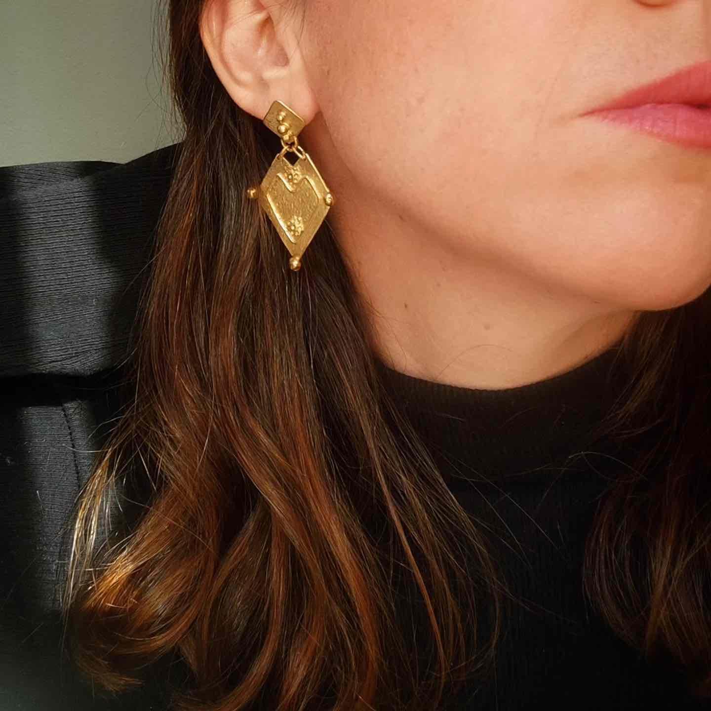 Pendientes dorados con diseño geométrico en forma de rombo, elegantes y modernos, ideales para ocasiones especiales.