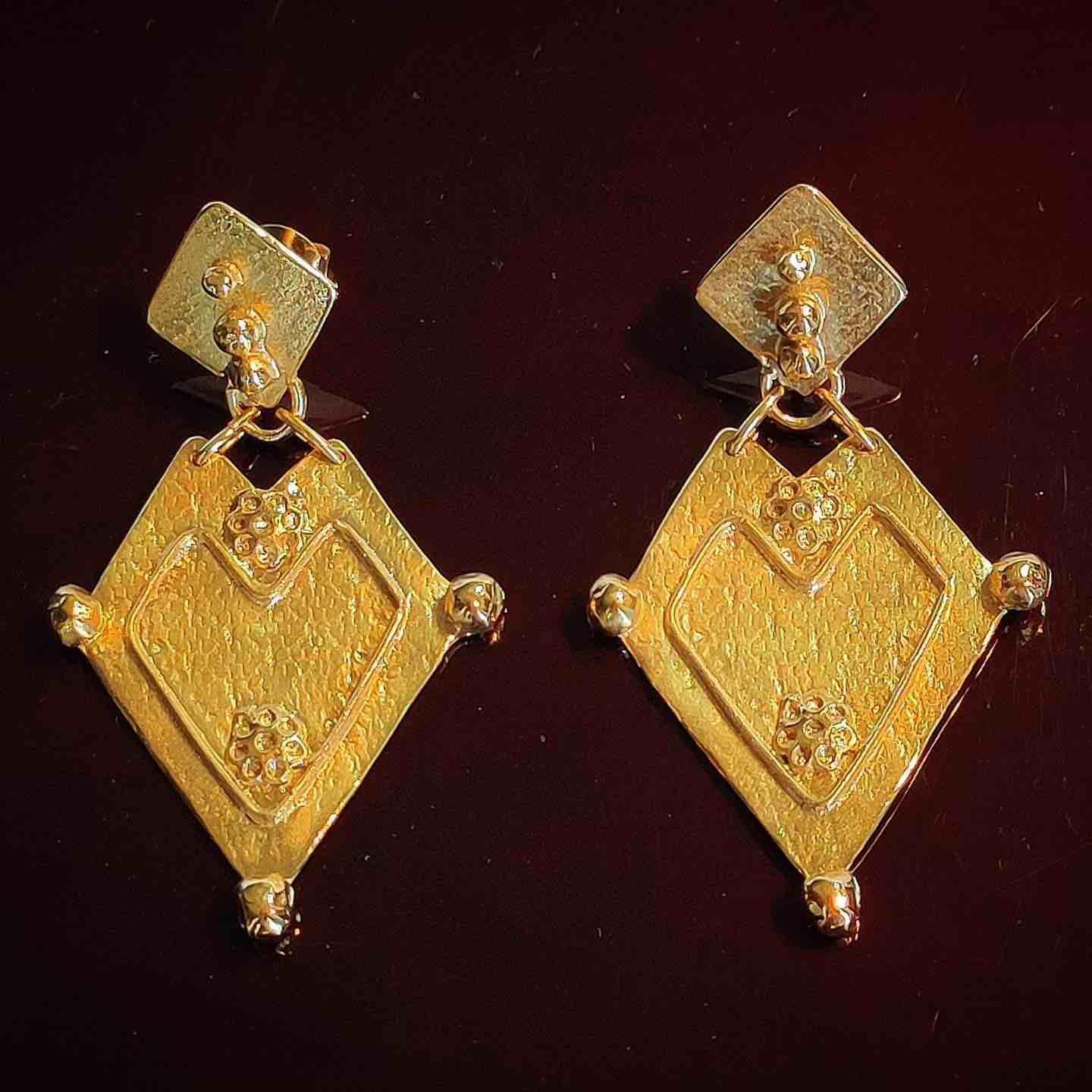 Pendientes de oro con diseño en forma de corazón y detalles texturizados, elegantes y modernos.