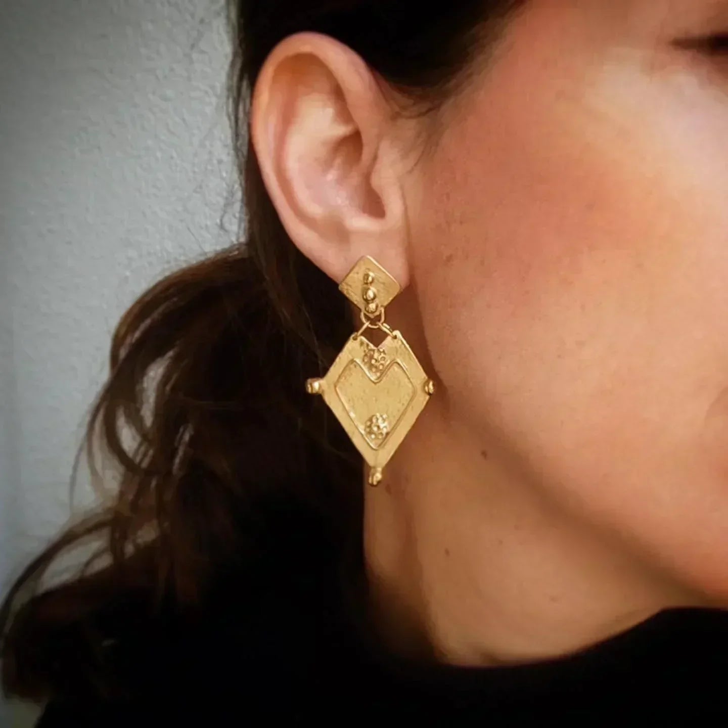 Pendientes colgantes dorados de diseño geométrico con textura, perfectos para ocasiones elegantes.