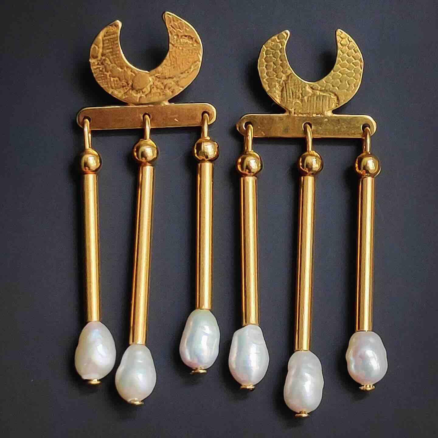 Pendientes dorados con perlas de agua dulce, diseño moderno con detalle de media luna, elegantes y sofisticados.