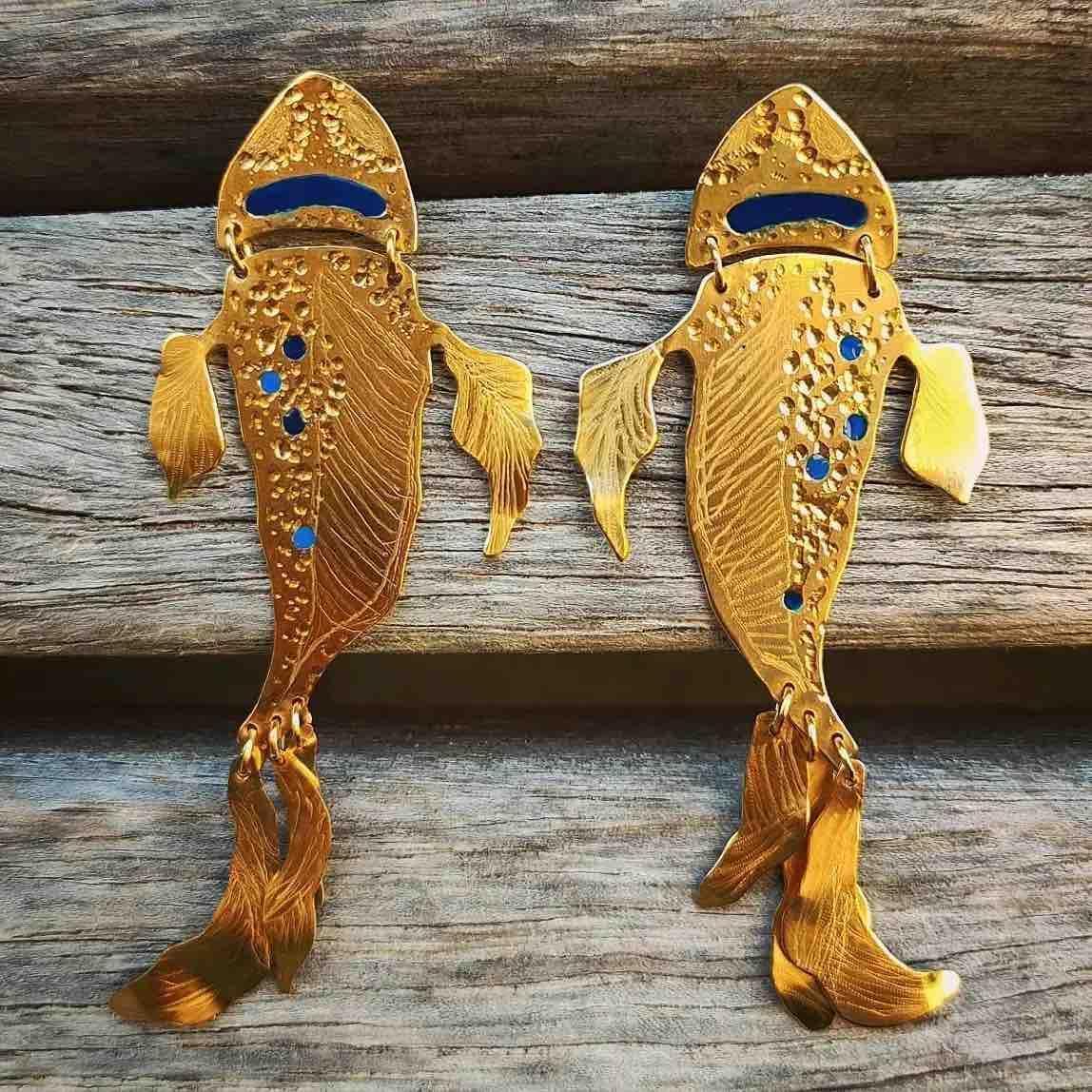 Pendientes de pez dorados con detalles azules y diseño elegante, perfectos para un look artístico y único.