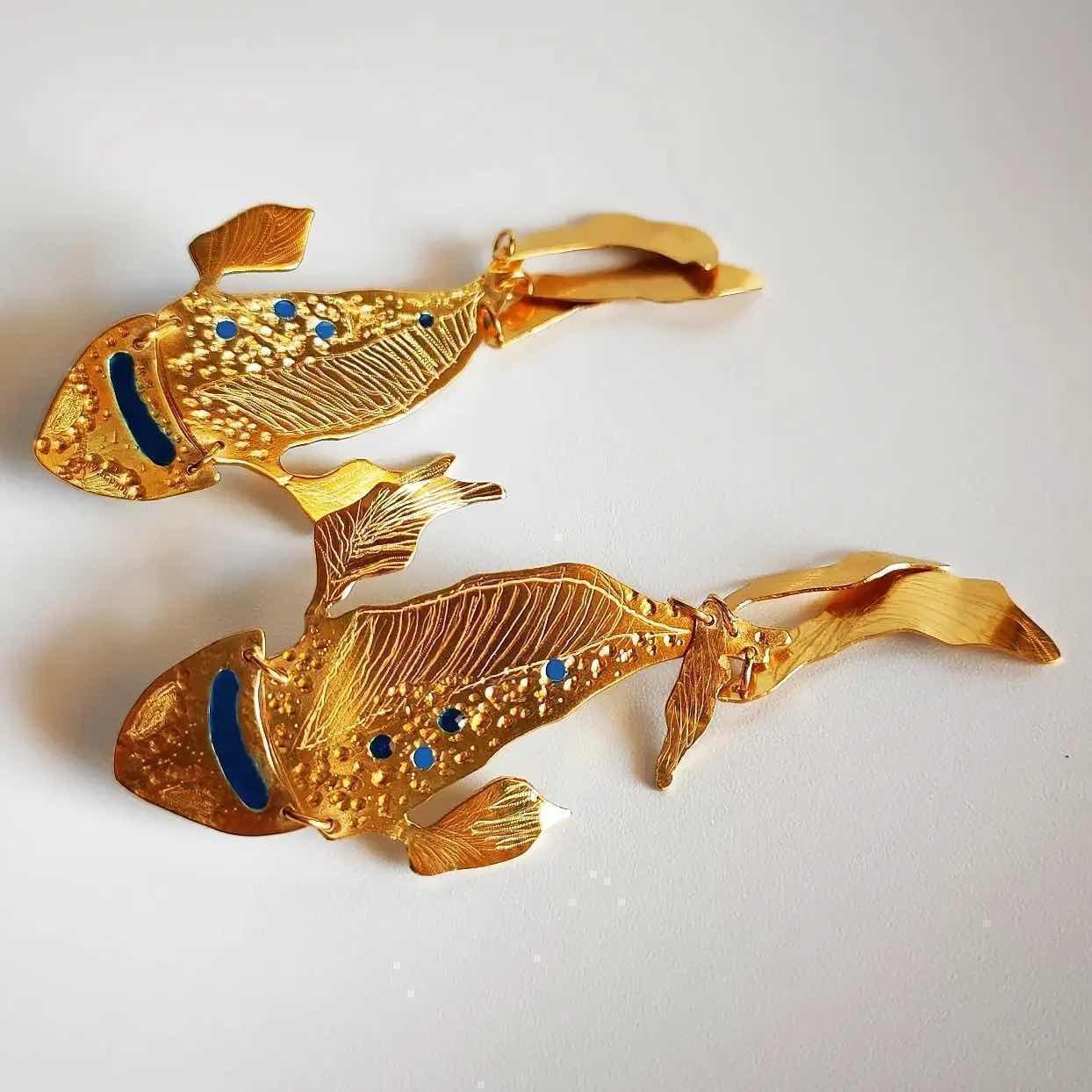 Pinzas de pez doradas con detalles azul brillante, elegantes y artesanales, perfectas para un toque distintivo en peinados.