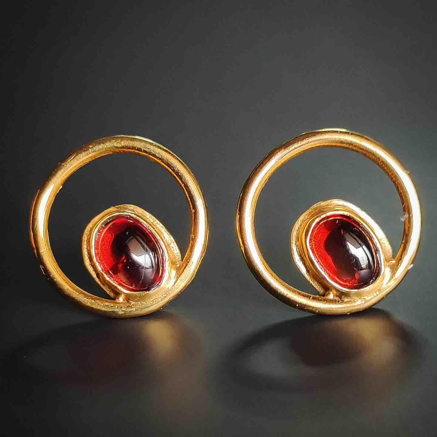 Pendientes de oro con diseño circular y piedra roja, ideales para ocasiones elegantes.