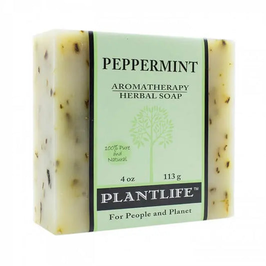 A rectangular bar of peppermint herbal soap with visible botanical flecks and a pale green wrapper featuring a tree.