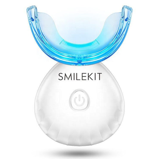 Kit de blanqueamiento dental con férula azul LED y base blanca recargable con botón de encendido sobre fondo blanco.