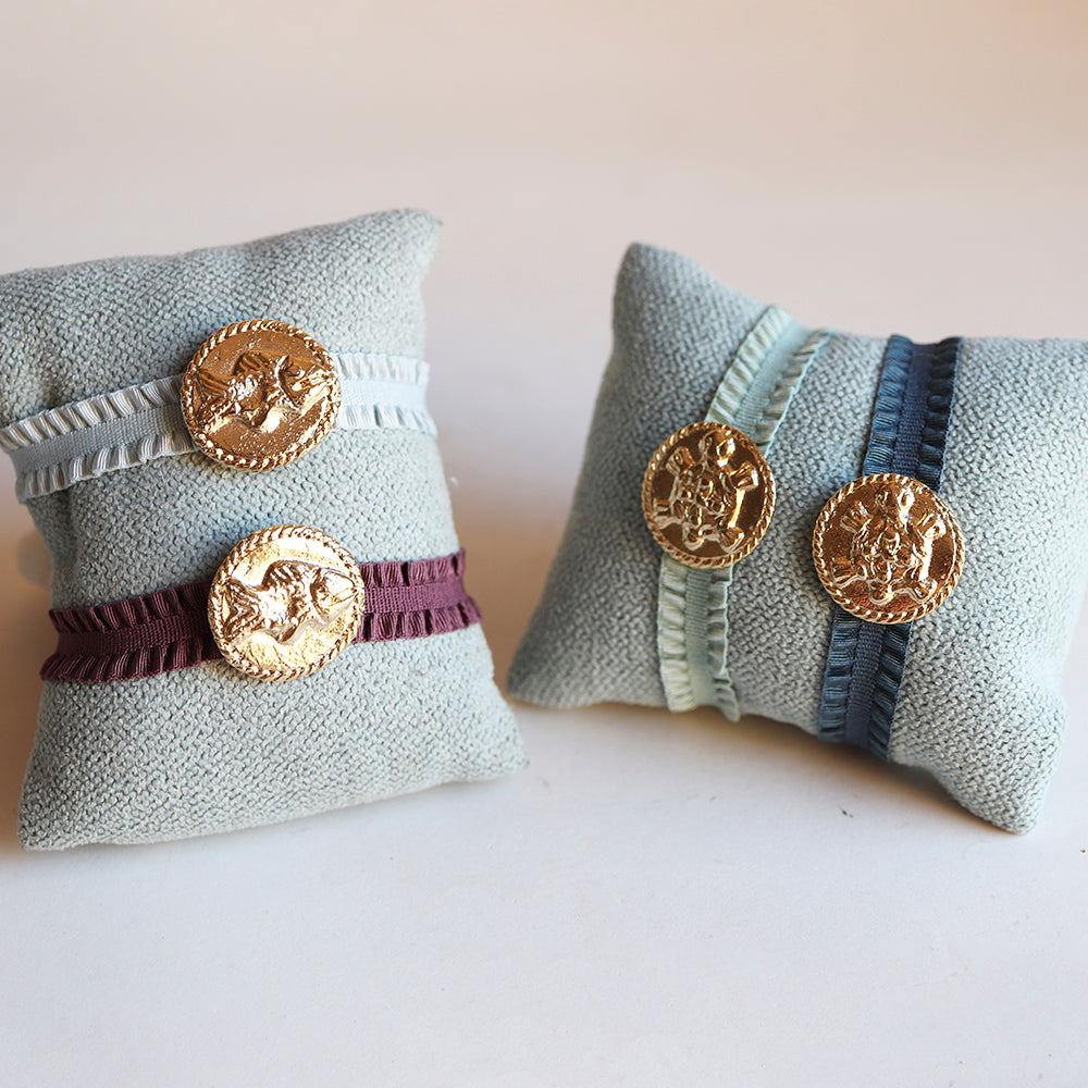 Pulseras de tela en azul, verde y burdeos con medallas doradas, estilo bohemio y elegante.