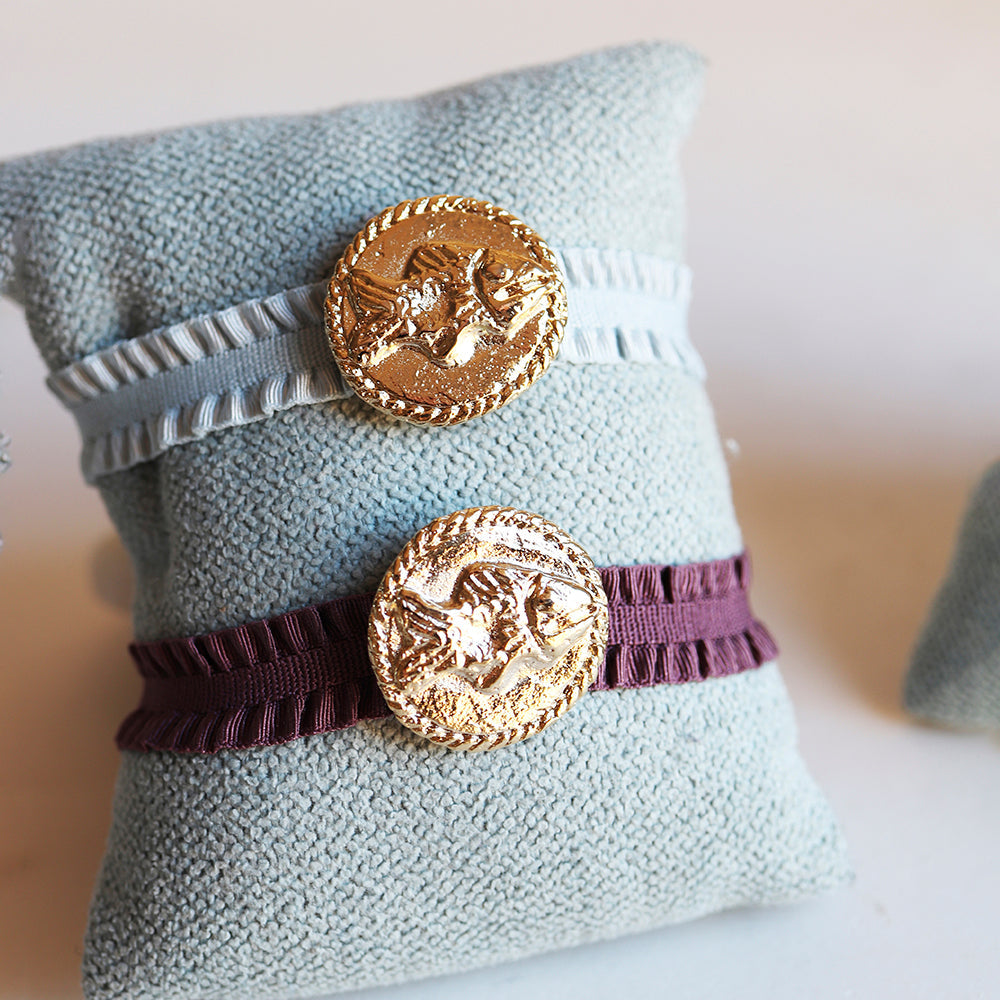 Pulseras de tela en azul claro y burdeos con botón dorado de diseño clásico. Perfectas para un estilo elegante.