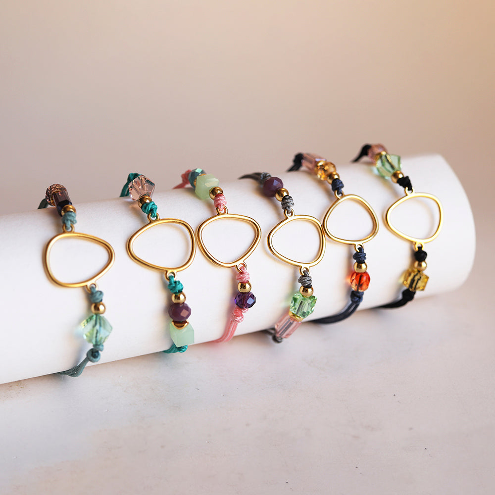 Pulseras de colores pastel con cuentas de vidrio y soporte dorado en forma de triángulo, estilo bohemio.