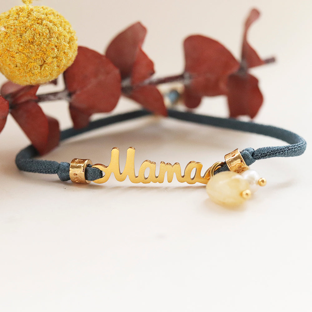 Pulsera azul de gamuza con nombre "Mama" en dorado y cuentas de piedra amarilla. Perfecta para regalo.