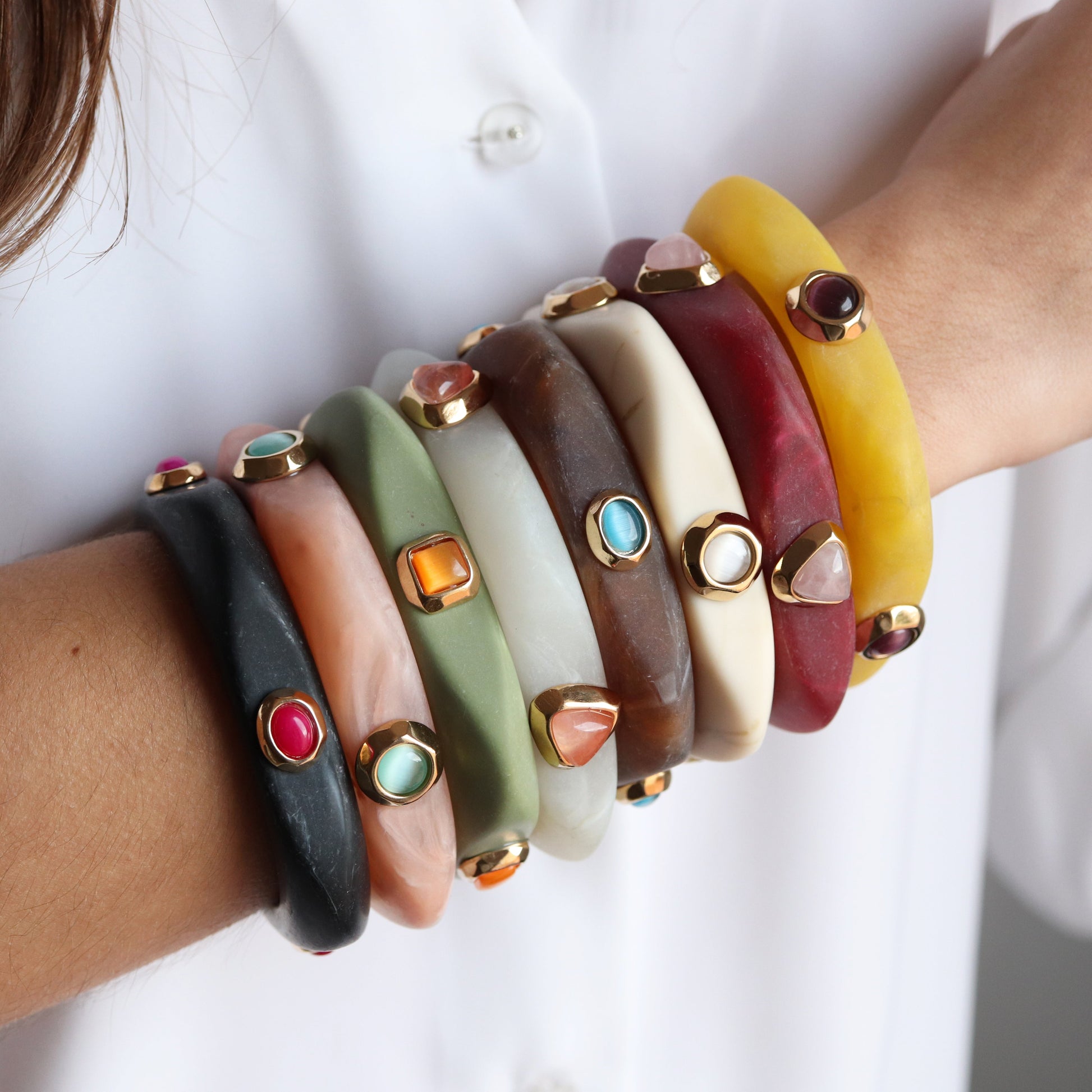 Brazaletes de resina en tonos pastel y vibrantes, con detalles dorados y piedras de colores. Ideal para un estilo moderno.