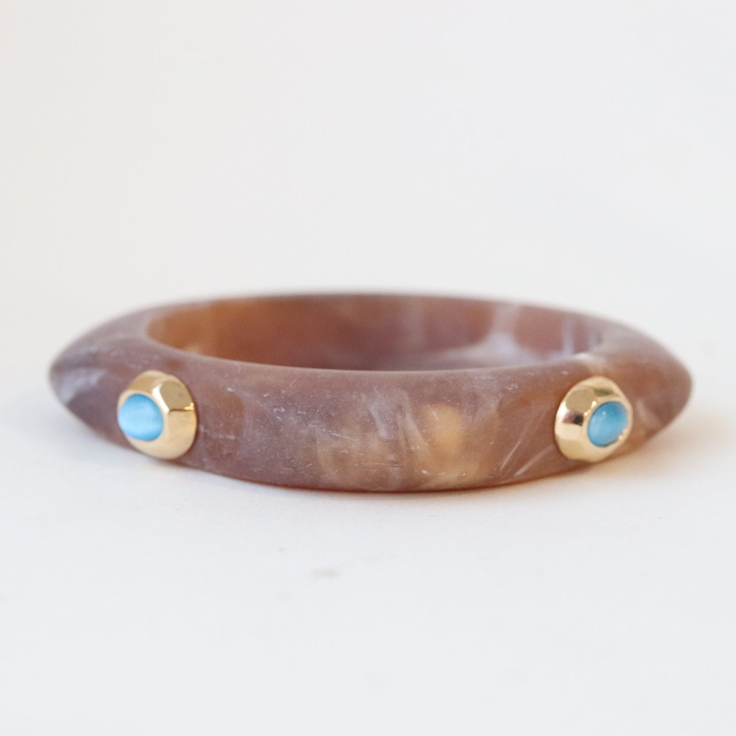 Pulsera de cuarzo rosa con detalles dorados y piedras turquesas, estilo moderno y elegante.