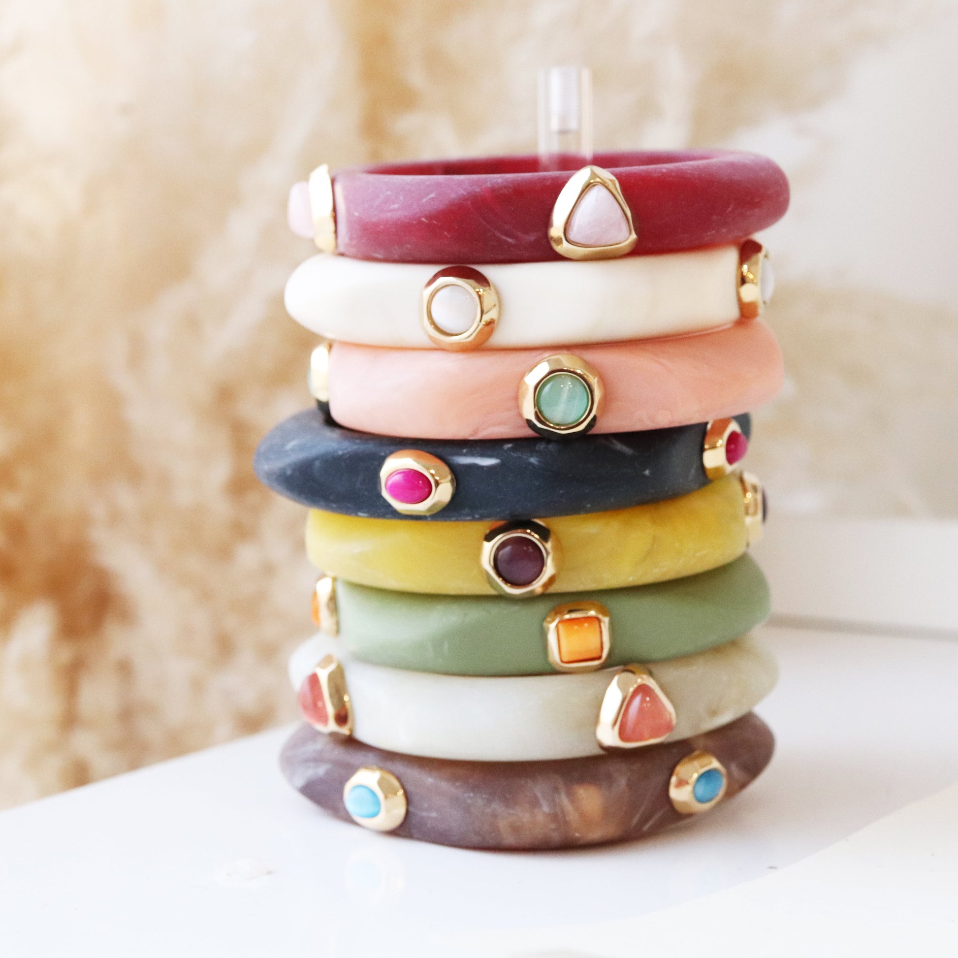 Pulseras de resina en tonos variados con detalles dorados, estilo bohemio y contemporáneo.
