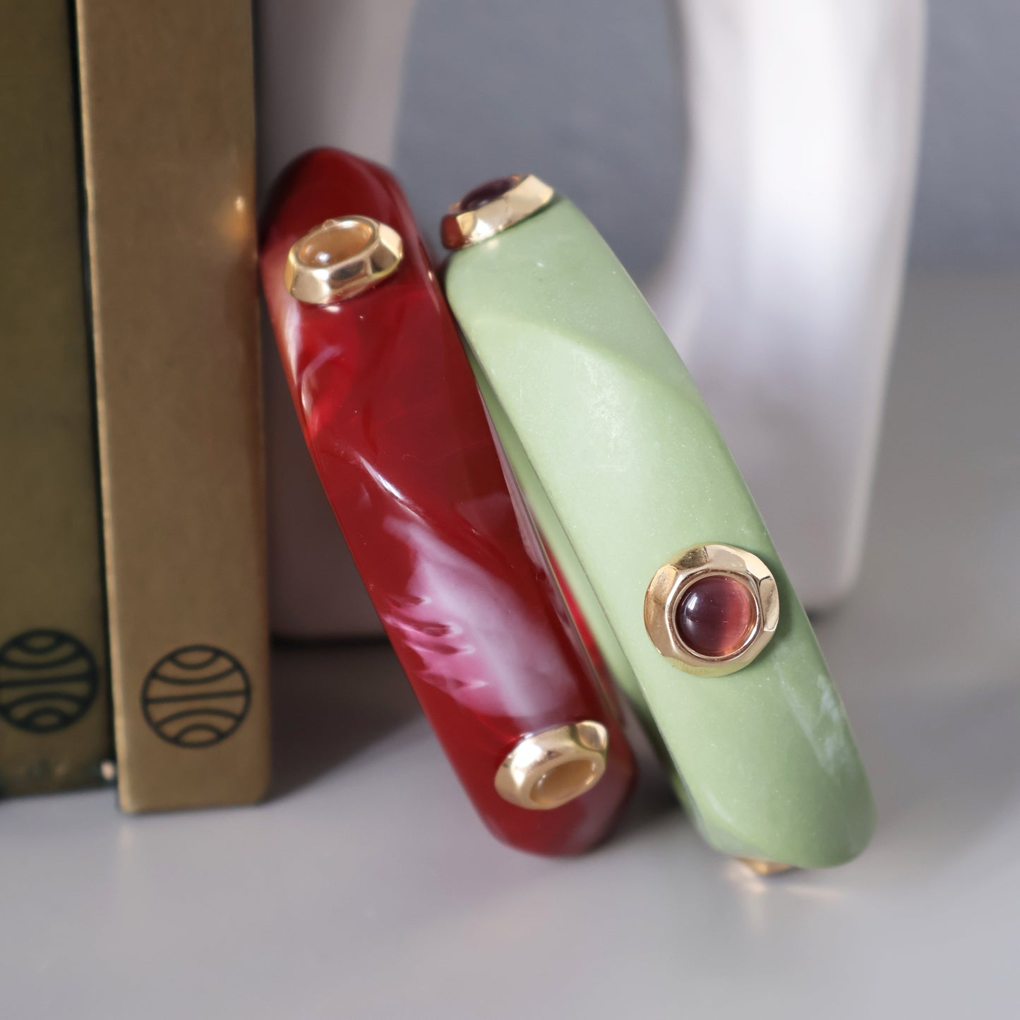 Pulsera verde y roja de resina con detalles dorados y piedras, estilo moderno y elegante para complementar cualquier outfit.