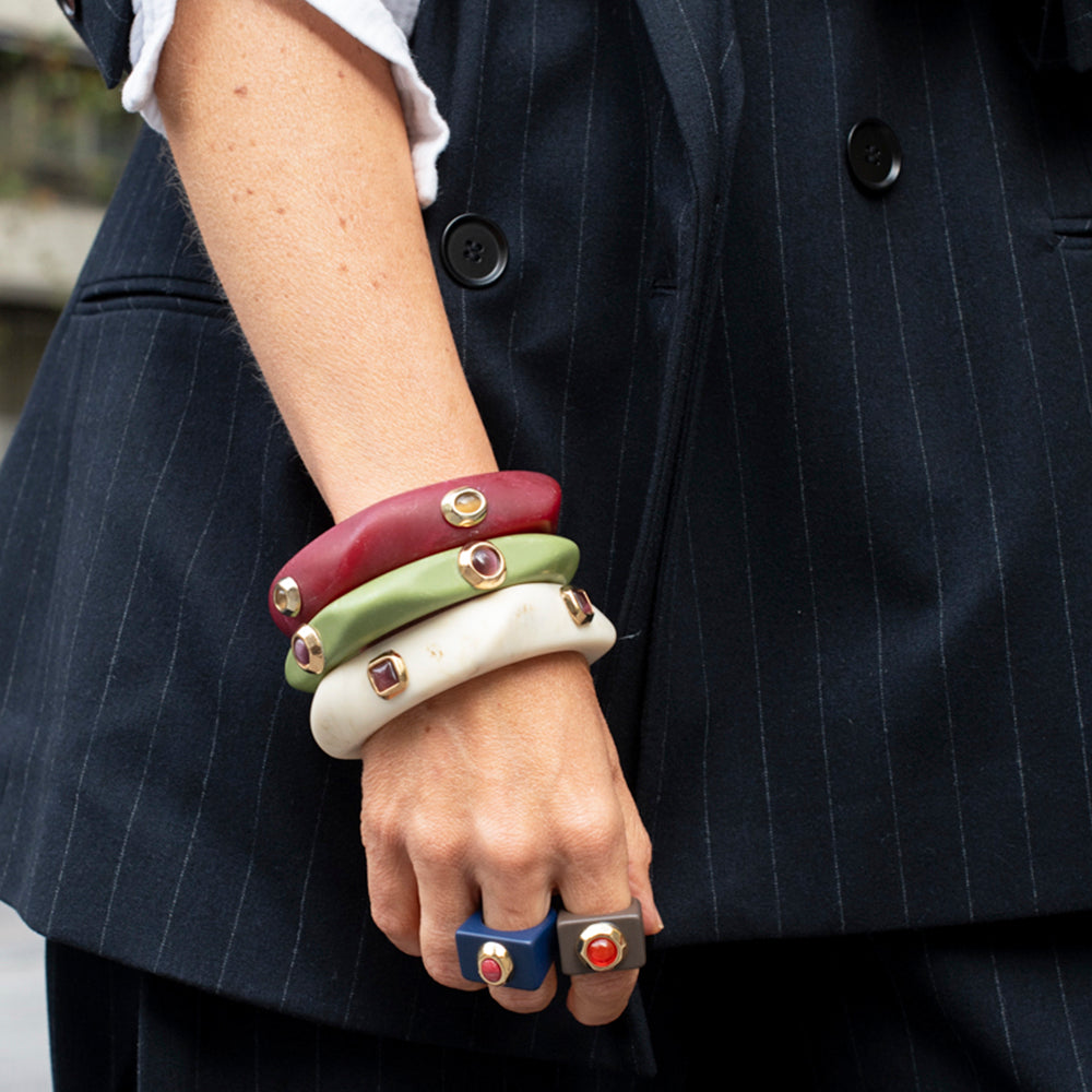 Pulseras de resina en colores rojo, verde, blanco y azul, con detalles metálicos, estilo moderno y elegante.