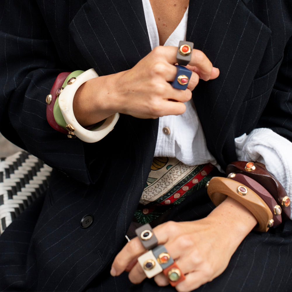 Pulseras de resina en tonos verde, negro, marrón y crema, con detalles de metal, estilo moderno y elegante.