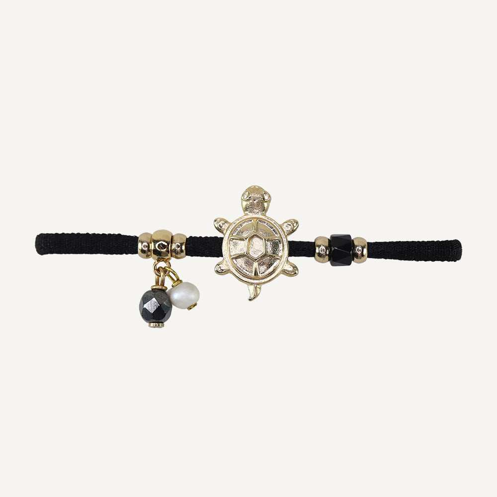 Pulsera negra de cordón con charm de tortuga dorada y perlas, piedras negras y doradas. Estilo bohemio.
