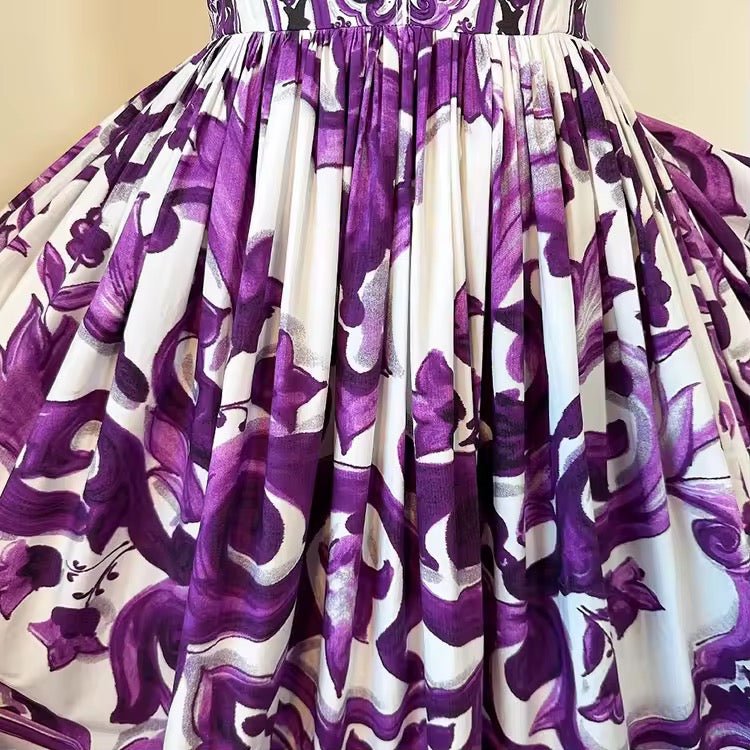 Purple and white floral-patterned A-line dress, made of lightweight fabric with pleated detail. Perfect for summer events.