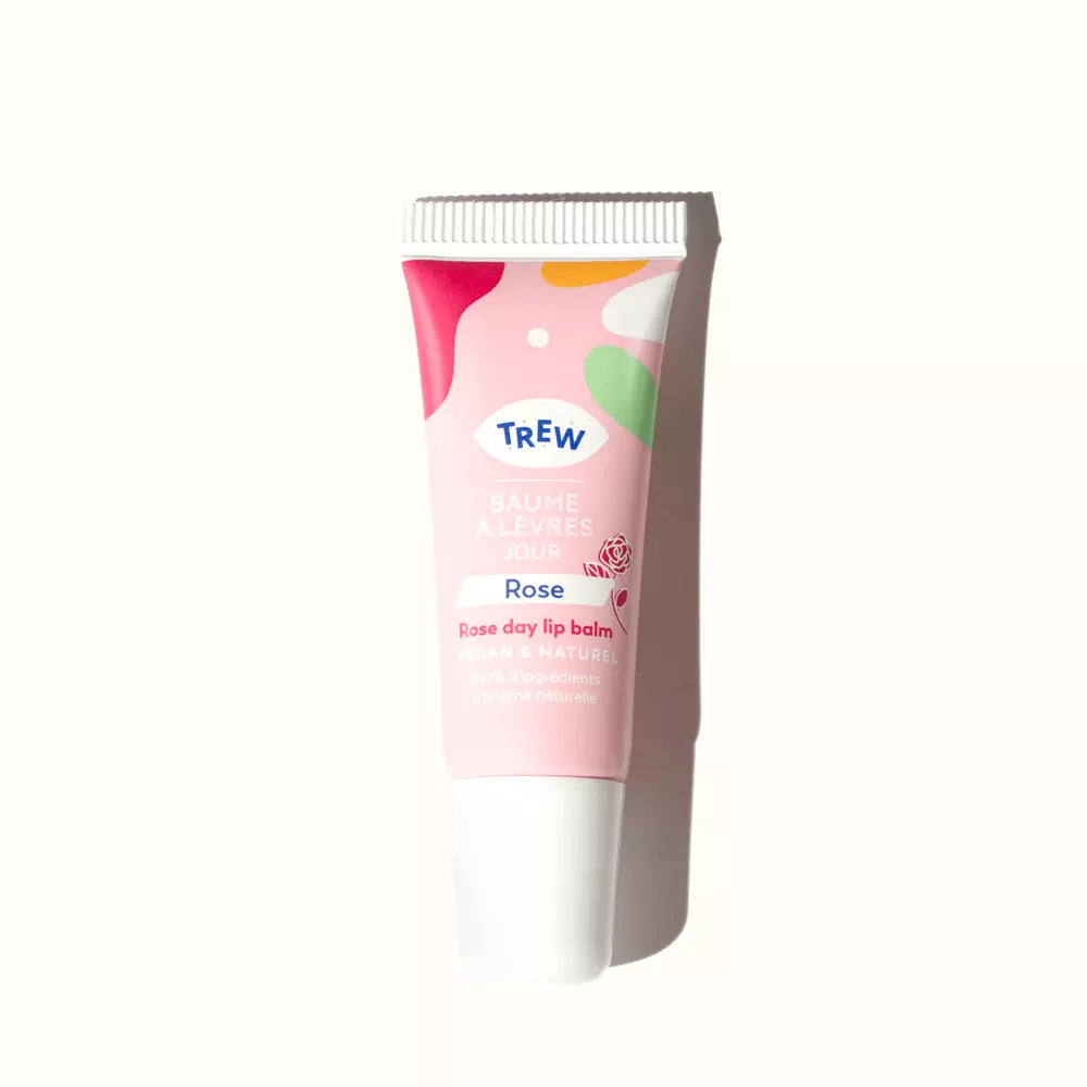 Pale pink lip balm tube featuring abstract colorful shapes, a rose illustration, and Trew branding text.