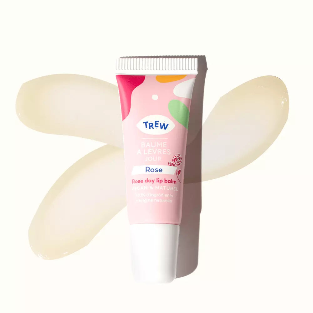 Trew pink rose lip balm tube placed over two transparent, pale yellow balm smears on a white background.