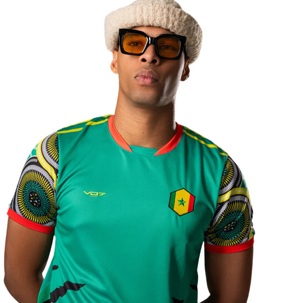 Maillot VO7 vert à motifs africains sur les manches et écusson du Sénégal, porté par un mannequin stylé.