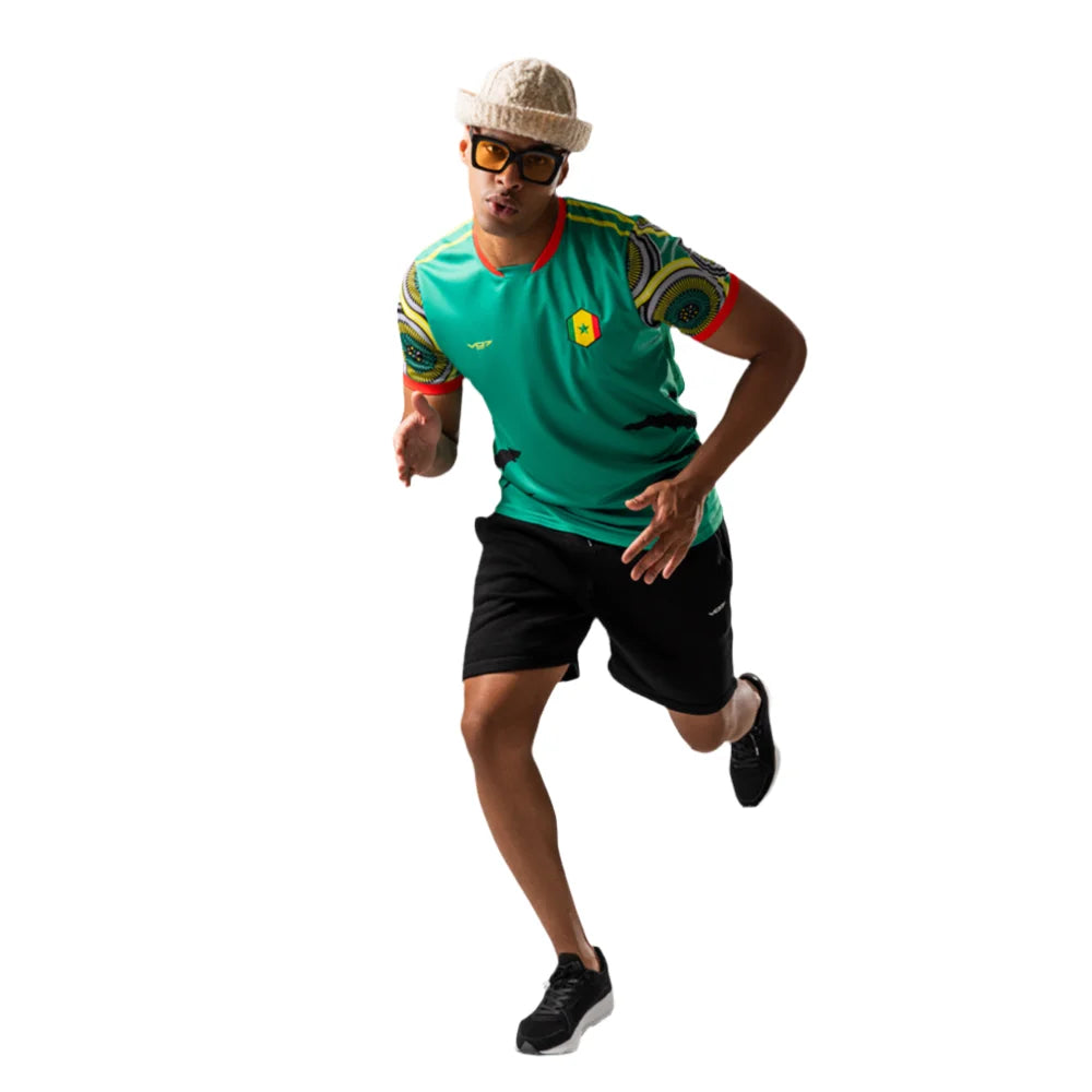Maillot VO7 Sénégal vert à motifs africains sur les manches, col rouge et logo aux couleurs du drapeau national.