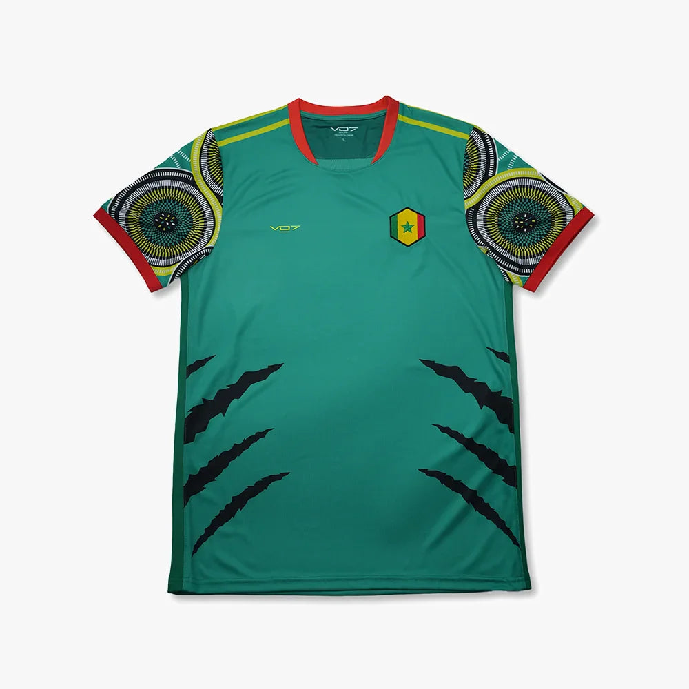 Maillot VO7 vert, col rouge, manches à motifs géométriques, logo Sénégal et griffures noires sur le devant.