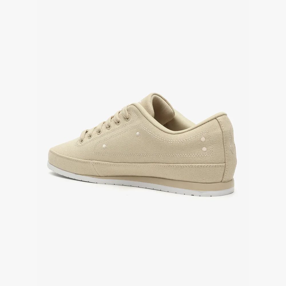 Basket VO7 Yacht 10 beige en toile, profil bas avec lacets assortis, surpiqûres apparentes et semelle blanche plate.