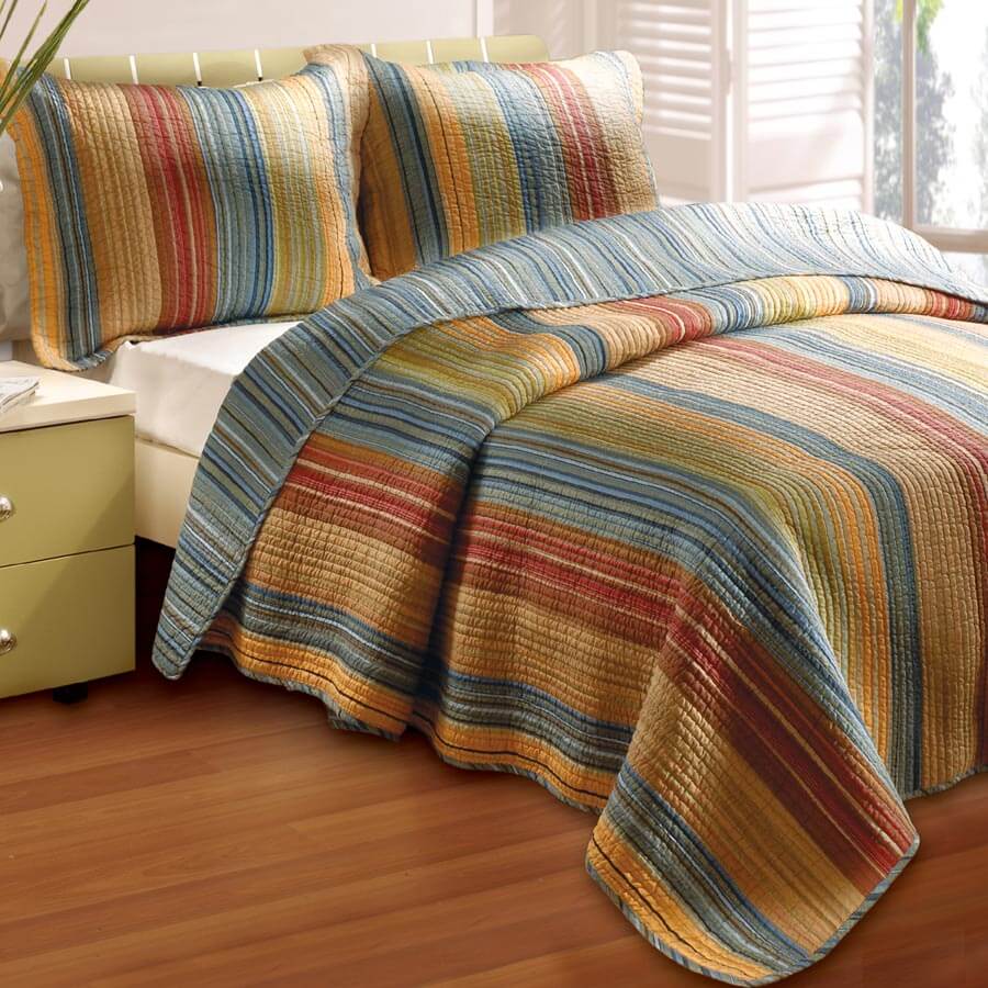 Southwest-style quilted bedding set featuring multi-colored vertical stripes in warm desert tones of gold, blue, and red.