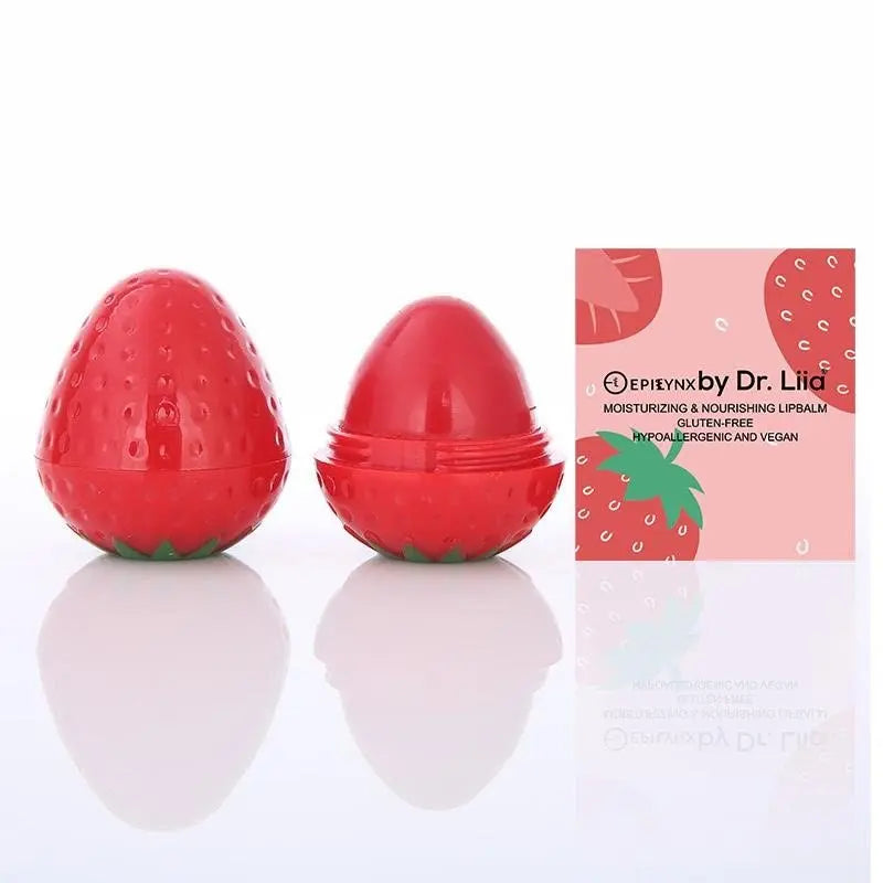 Two strawberry-shaped red lip balm containers with textured surfaces, next to a matching product box on a white base.