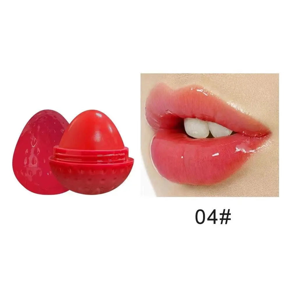 Red strawberry-shaped lip butter balm container next to lips wearing a glossy red tint, labeled 04#.