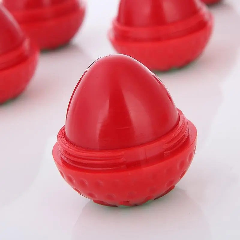 Bright red, strawberry-shaped lip butter containers with textured outer shells on a plain white background.