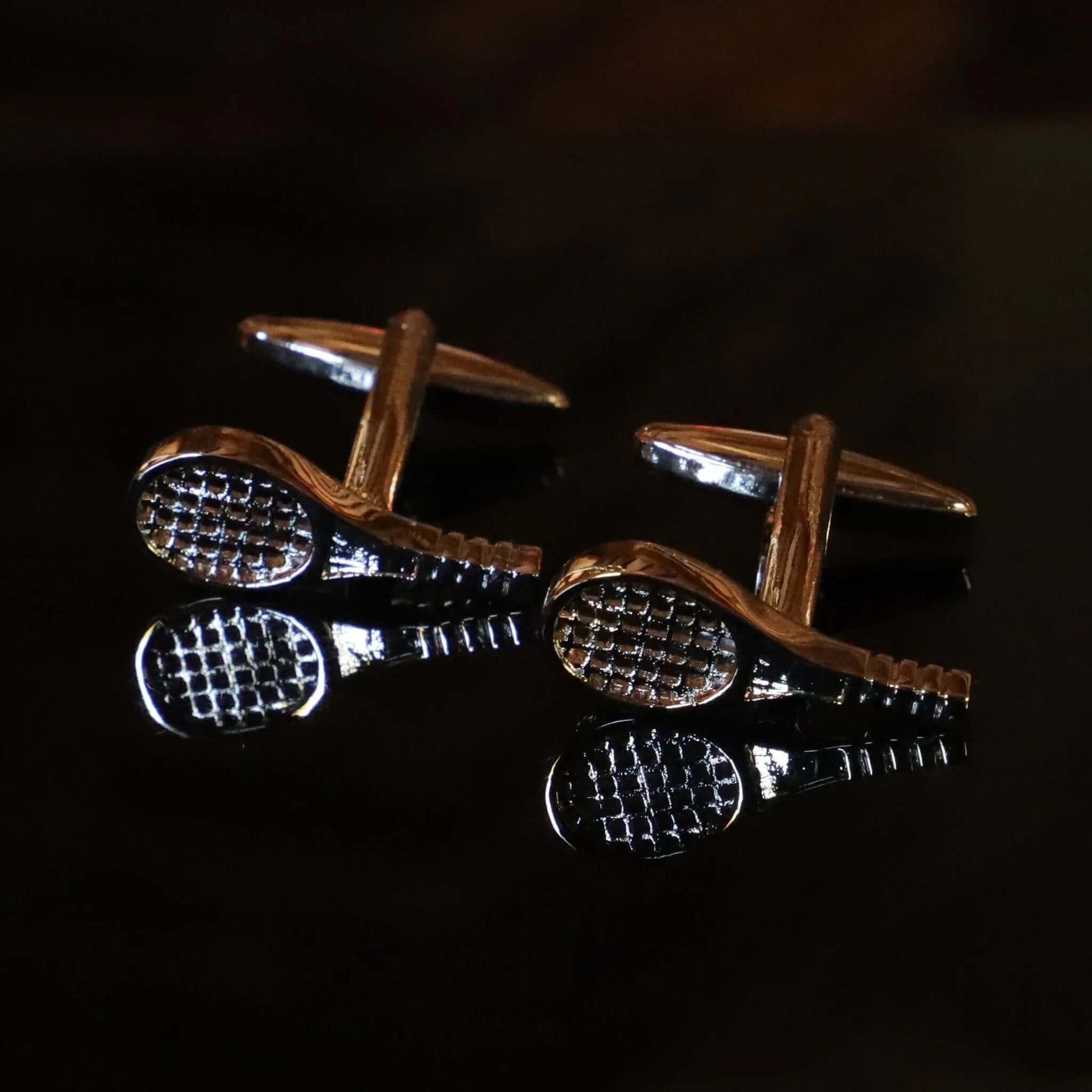 Gemelos raqueta tenis plateados acero inoxidable para tenistas con reflejos fondo negro elegantes