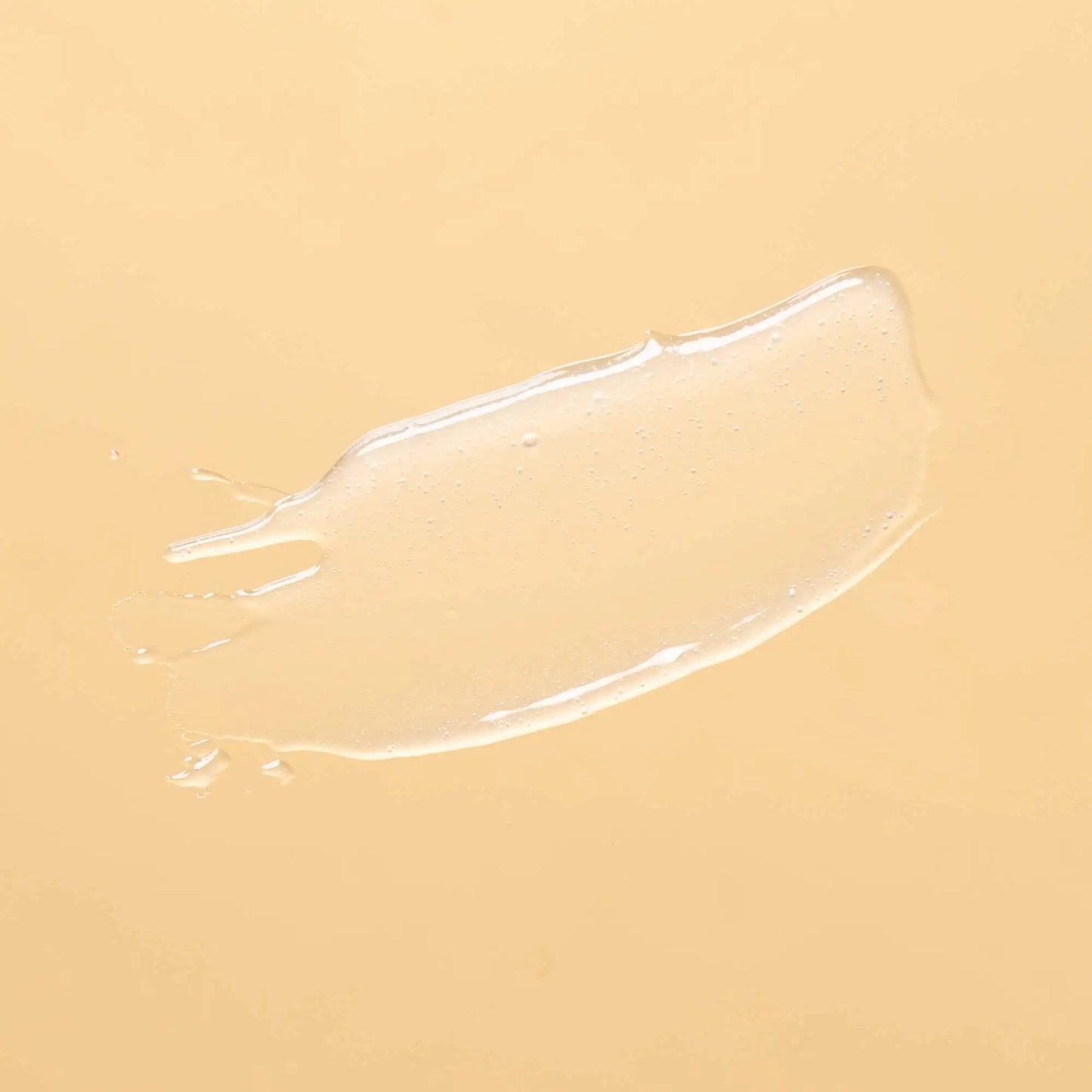 A clear, glossy gel smear on a solid light yellow background.