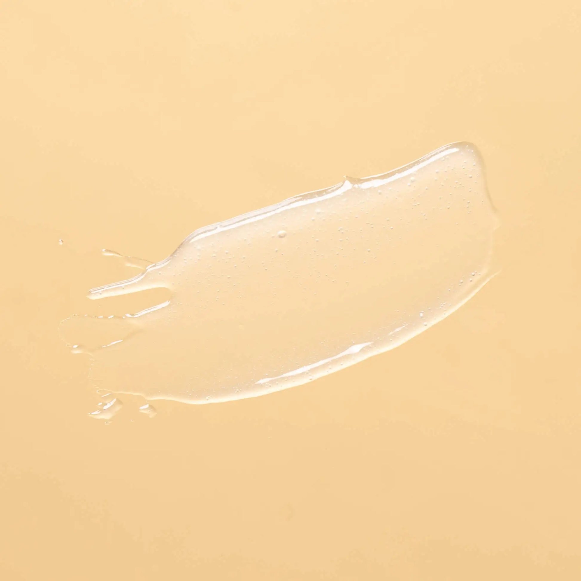 A clear, glossy gel smear on a solid light yellow background.