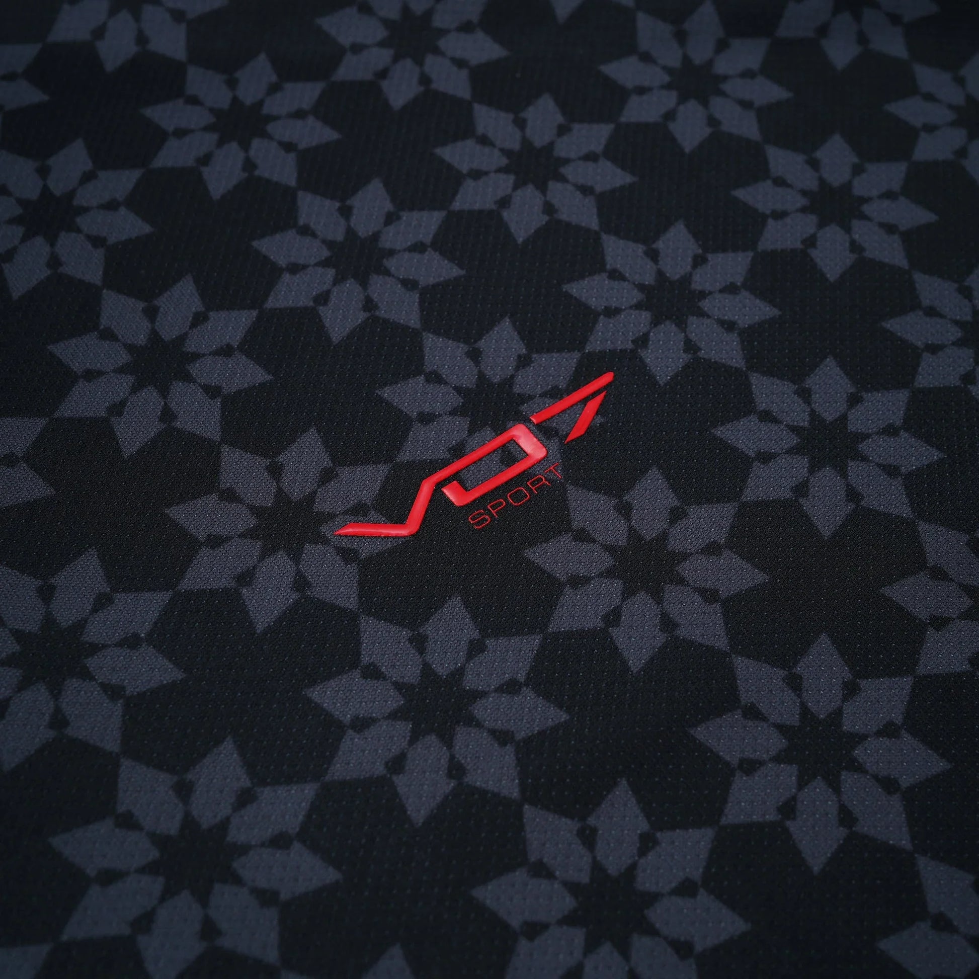 Maillot VO7 noir en tissu technique à motifs géométriques gris, avec logo VO7 SPORT rouge contrastant en relief.