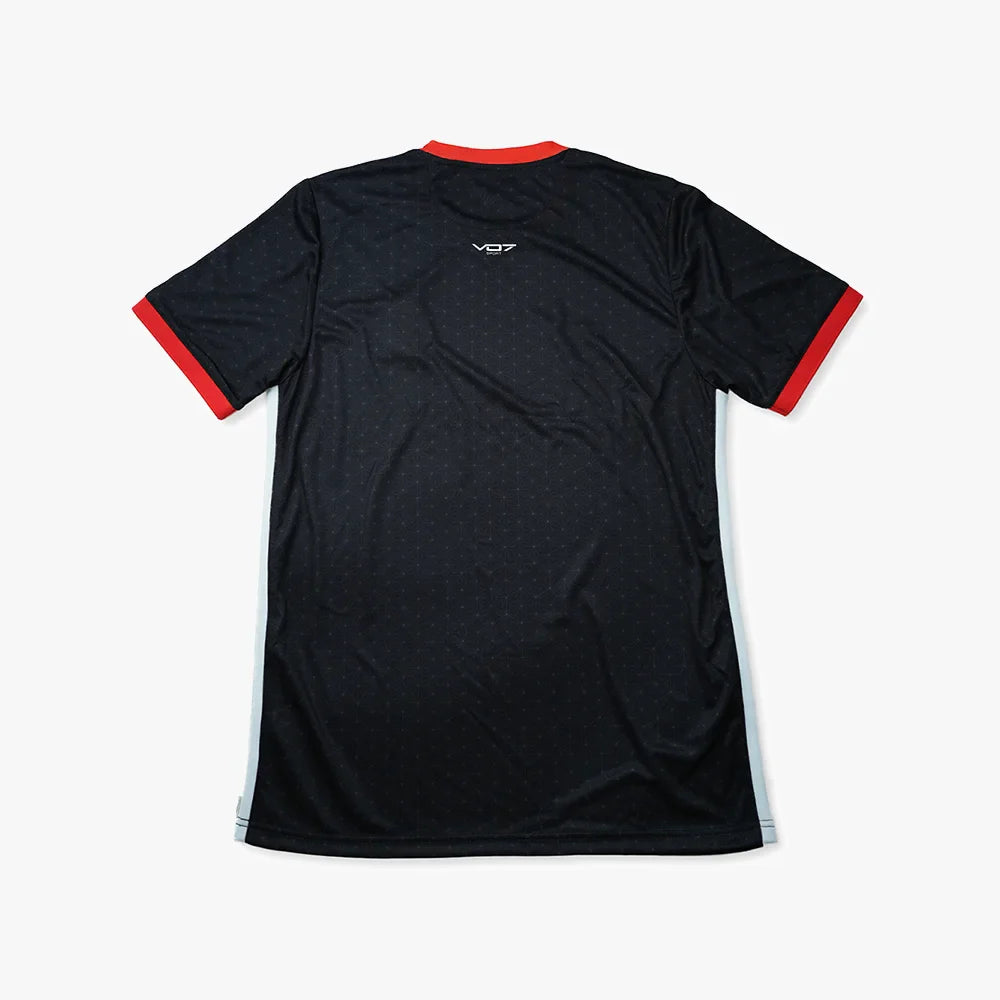 Maillot sport VO7 noir à motifs géométriques, col et bords de manches rouges, logo blanc au dos, matière technique.