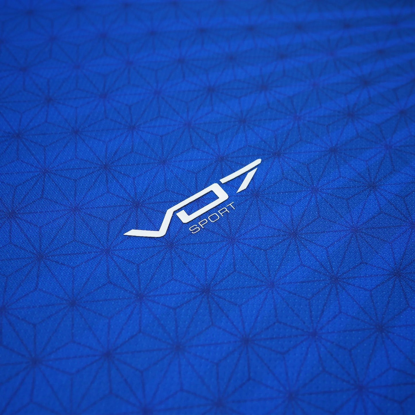 Maillot VO7 bleu à motif géométrique texturé avec logo blanc VO7 Sport central. Tissu technique au fini mat élégant.