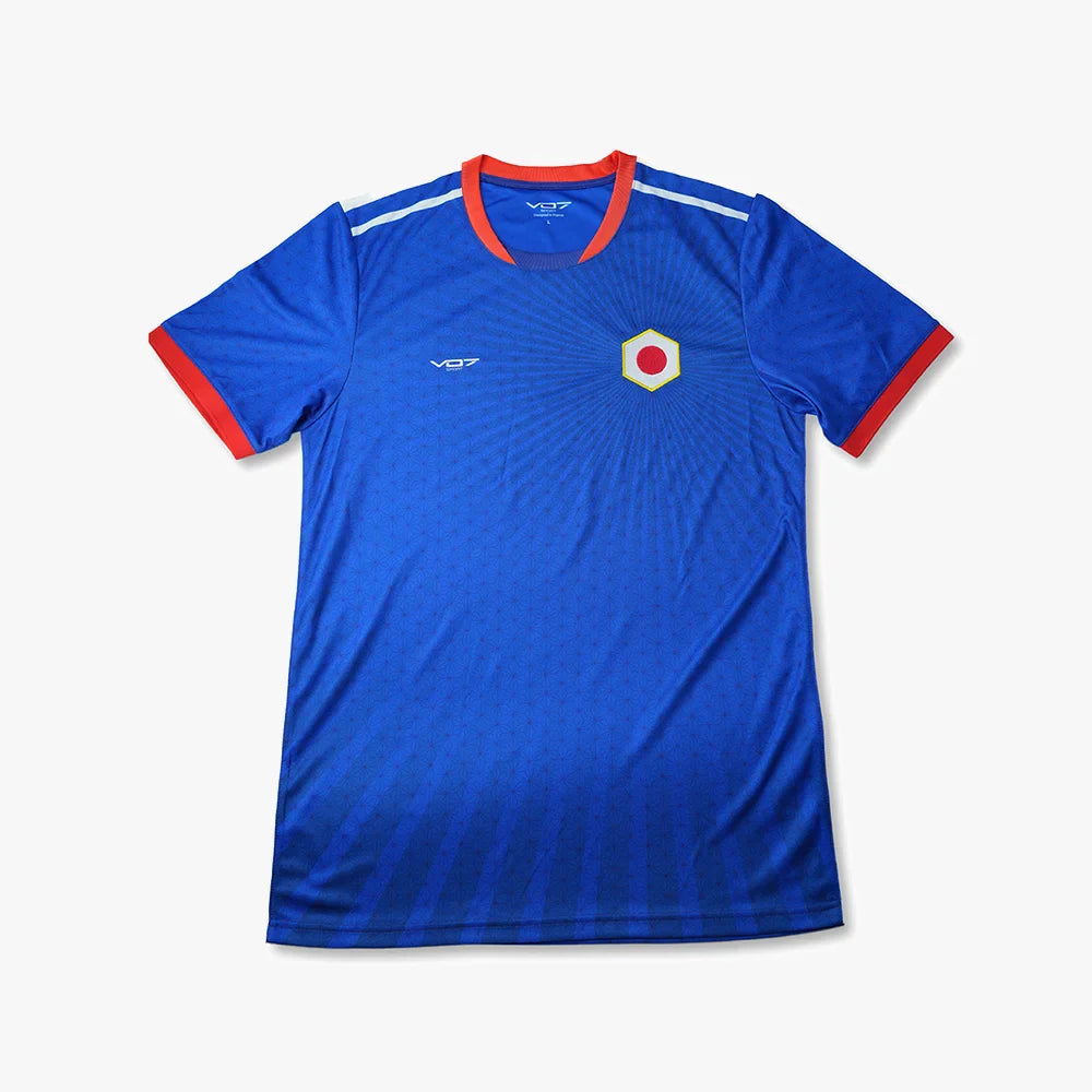 Maillot bleu VO7, style Japon, col et bords de manches rouges, motif floral subtil, logo et écusson hexagonal central.