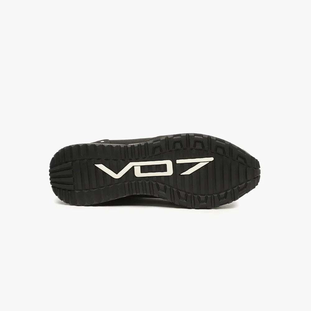 Semelle extérieure noire crantée de basket VO7, arborant le logo blanc texturé en relief au centre sur fond blanc.